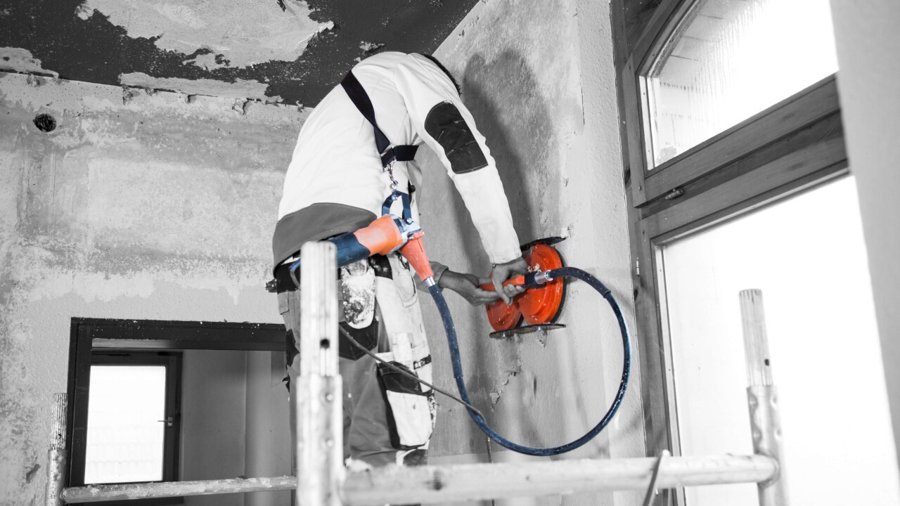 Maschinelles Entfernen von Tapeten mit der Chameleon an der Wand