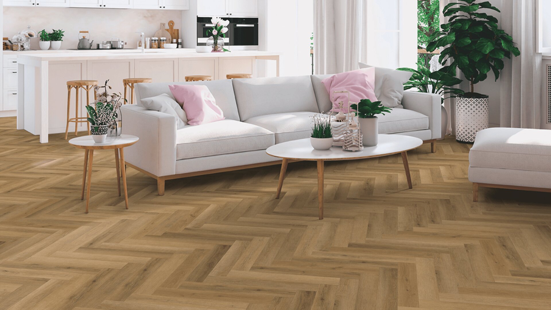 Ein modernes Wohnzimmer mit hellem Fischgrätboden, einem weißen Sofa mit rosa und grauen Kissen, einem runden Couchtisch, grünen Pflanzen und einer offenen Küche im Hintergrund. Natürliches Licht durchflutet den Raum.