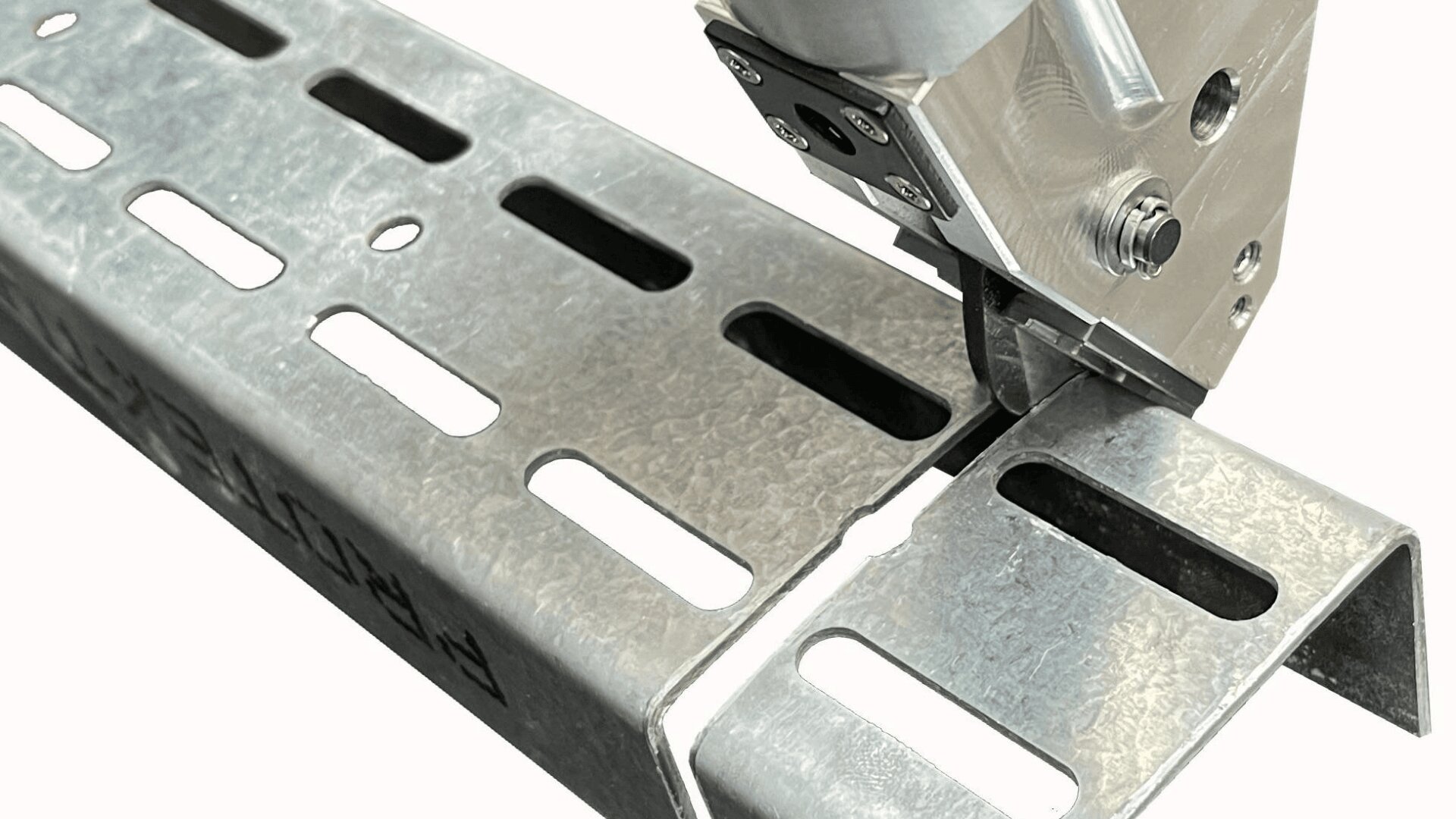 Eine Nahaufnahme eines Metallschneidwerkzeugs, das durch einen verzinkten Stahlkanal mit mehreren rechteckigen Löchern schneidet und einen sauberen Präzisionsschnitt zeigt.