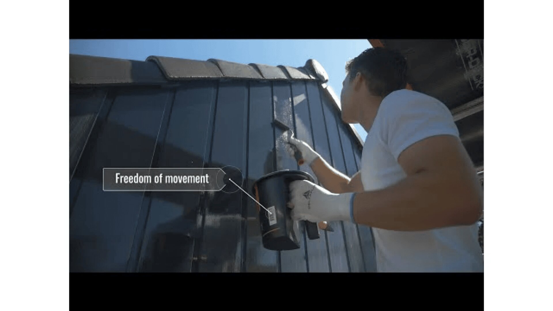 A person wearing gloves applies a substance to an exterior wall with a brush. Sunlight shines above, and a text bubble near the arm reads Freedom of movement.